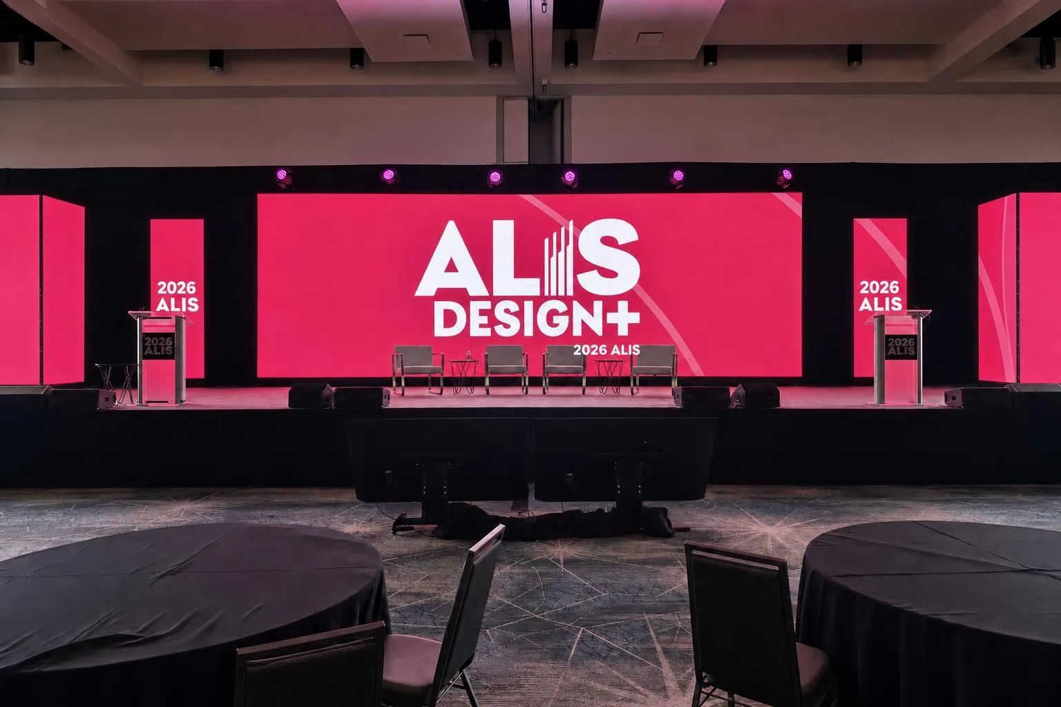 Low-angle view of truss, scenic, and lighting rigging above a corporate ballroom