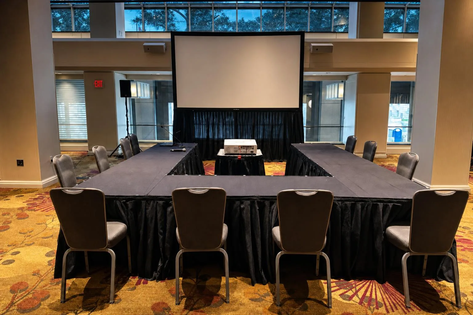 Empty breakout room with tables and AV powered on before attendees arrive
